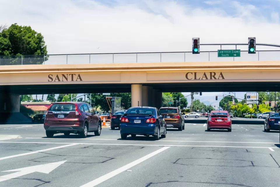 Cars passing under 101 freeway overpass with SANTA CLARA in large letters on the overpass